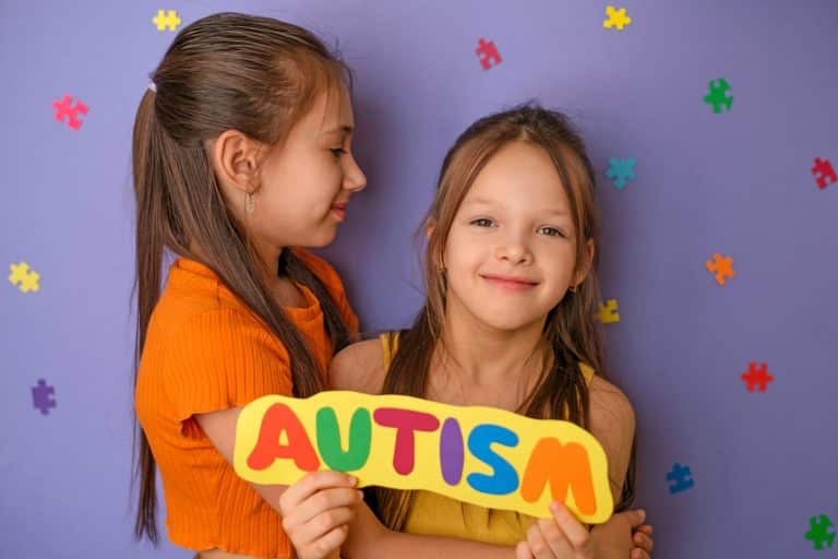 A girl hugs her sister with an autism spectrum disorder.